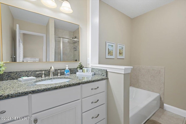 bathroom with plus walk in shower, tile patterned flooring, vanity, and a textured ceiling