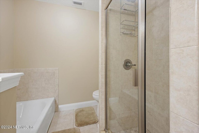 bathroom with tile patterned floors, separate shower and tub, and toilet