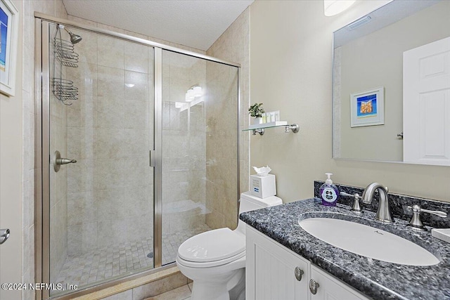 bathroom featuring a textured ceiling, vanity, toilet, and an enclosed shower