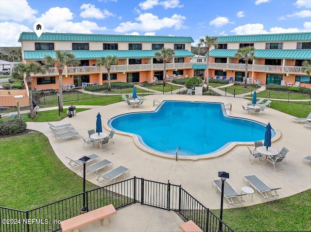 view of pool with a patio area and a lawn