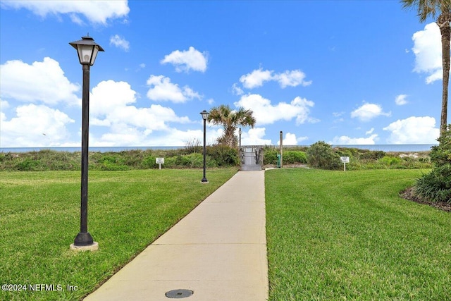 view of property's community with a yard and a water view