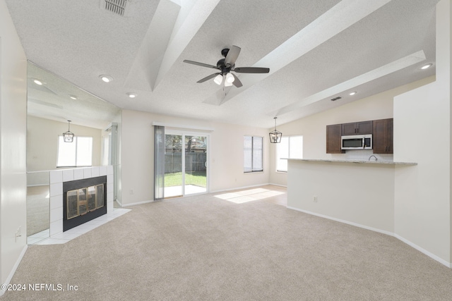 unfurnished living room with a textured ceiling, ceiling fan, a fireplace, and lofted ceiling