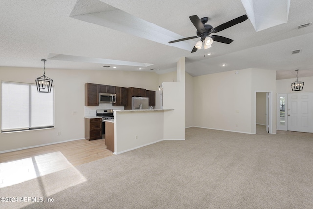 unfurnished living room with a textured ceiling, ceiling fan with notable chandelier, lofted ceiling, and light carpet