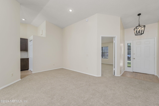 carpeted foyer with a notable chandelier