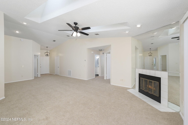 unfurnished living room featuring a textured ceiling, ceiling fan, a fireplace, and light carpet