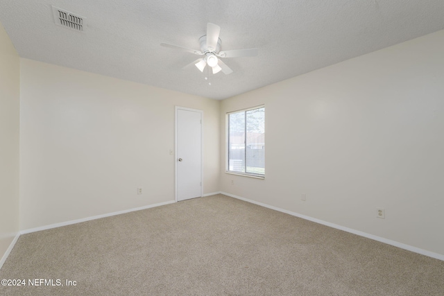 spare room with carpet flooring, ceiling fan, and a textured ceiling