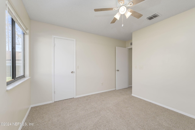 unfurnished bedroom with ceiling fan and light colored carpet