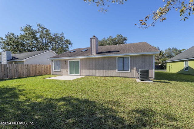 rear view of house with a lawn, cooling unit, and a patio area