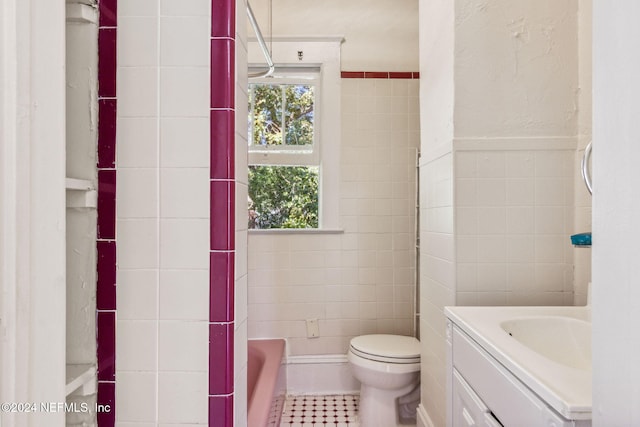 bathroom with vanity, a bath, tile patterned flooring, toilet, and tile walls