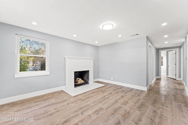 unfurnished living room featuring a fireplace and light hardwood / wood-style flooring