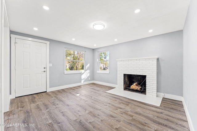 unfurnished living room with a fireplace and light hardwood / wood-style floors