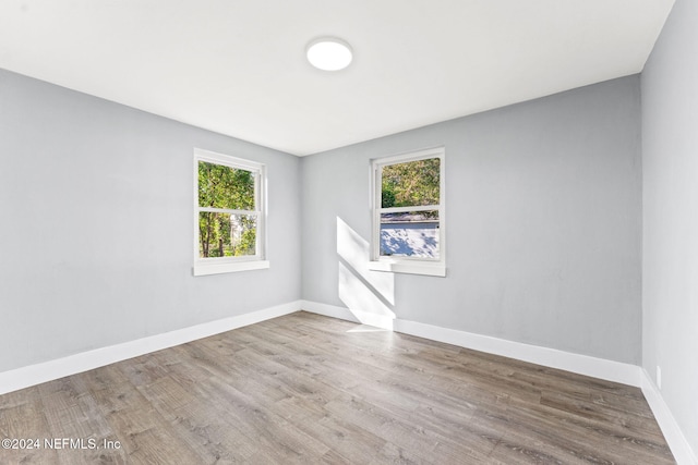 spare room with wood-type flooring and a wealth of natural light