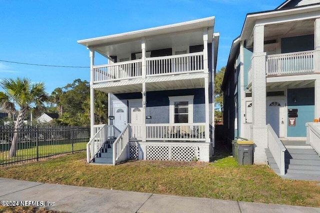 view of front of home featuring a balcony and a front lawn