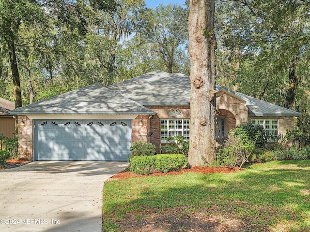 view of front of house featuring an attached garage, brick siding, concrete driveway, roof with shingles, and a front lawn