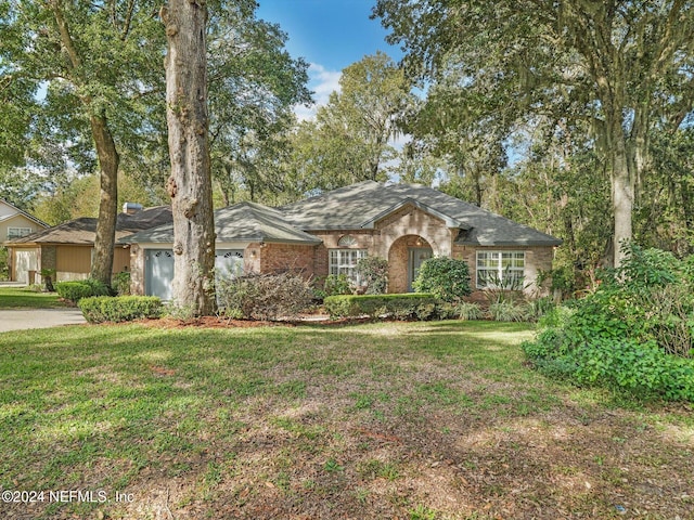 single story home with a garage, brick siding, driveway, and a front lawn