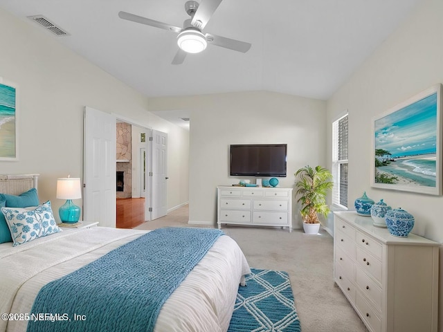 bedroom with visible vents, a ceiling fan, a high end fireplace, light carpet, and vaulted ceiling