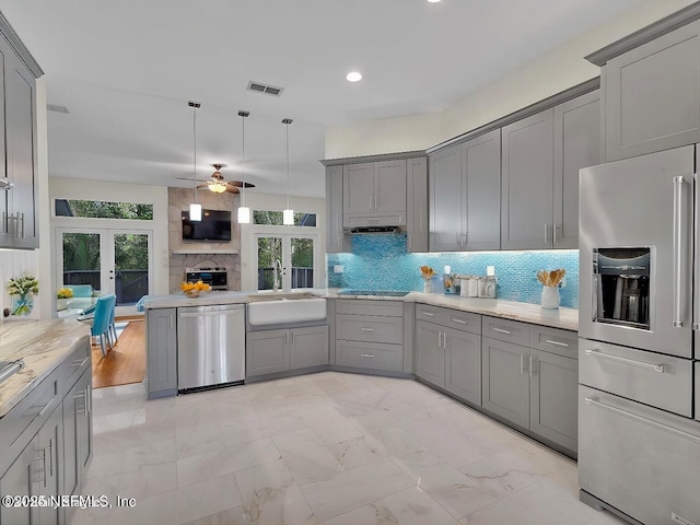 kitchen with appliances with stainless steel finishes, gray cabinets, and a sink