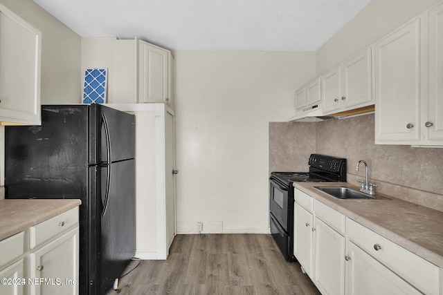 kitchen featuring black appliances, sink, light wood-type flooring, tasteful backsplash, and white cabinetry