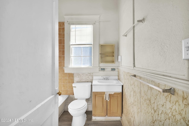 bathroom featuring vanity, wood-type flooring, tile walls, and toilet