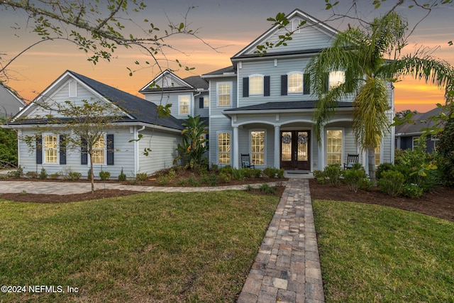 view of front of property featuring french doors and a lawn