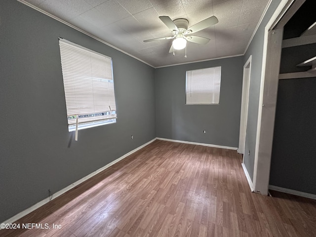 unfurnished bedroom with hardwood / wood-style floors, ceiling fan, and ornamental molding