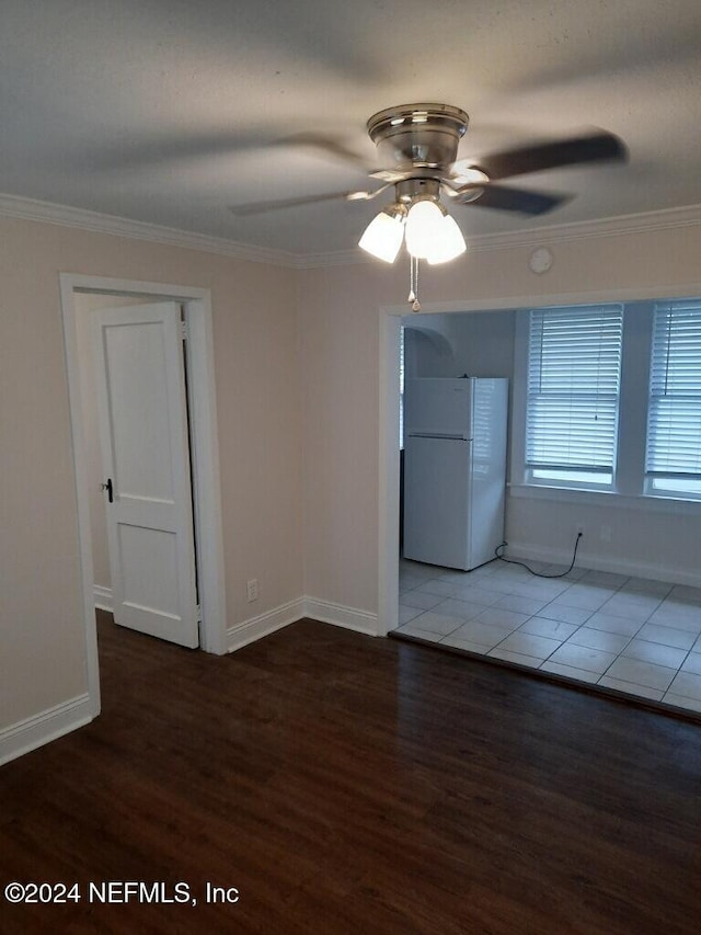 empty room featuring ceiling fan, dark hardwood / wood-style flooring, and crown molding