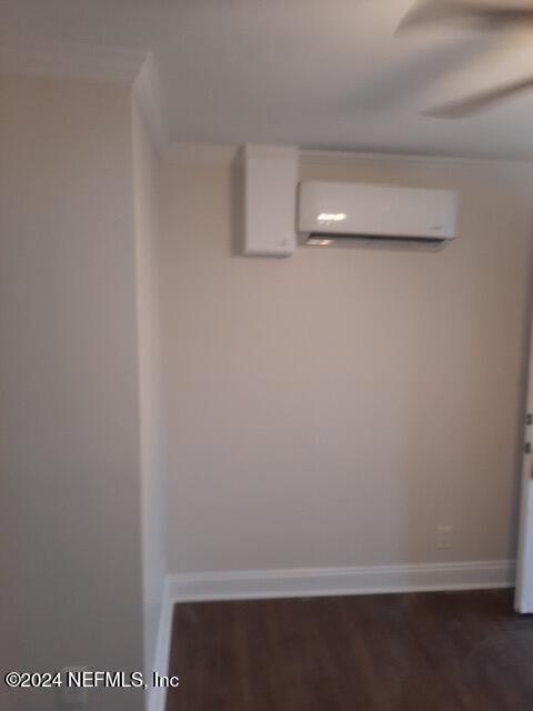 details with an AC wall unit and hardwood / wood-style floors