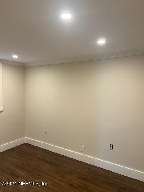 empty room featuring crown molding and dark hardwood / wood-style flooring