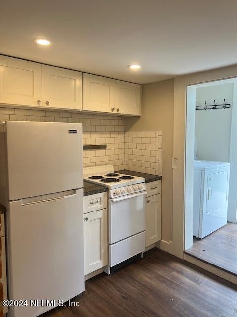 kitchen with white appliances, backsplash, dark wood-type flooring, white cabinets, and washer / dryer