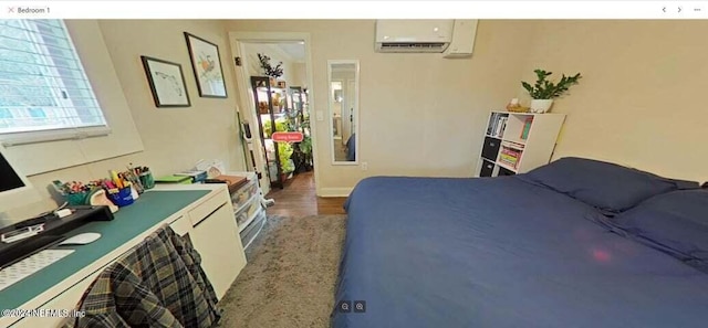 bedroom featuring dark hardwood / wood-style flooring and an AC wall unit