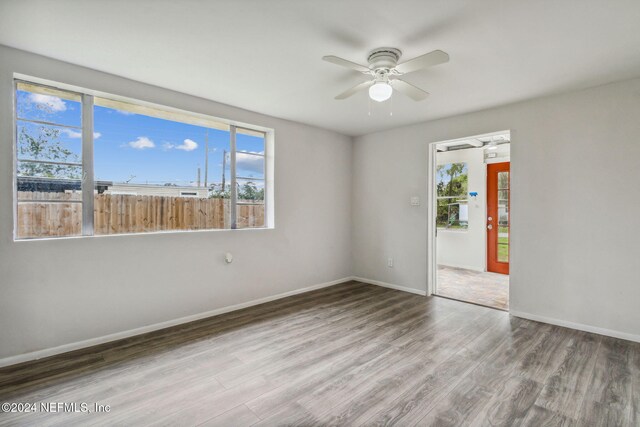 spare room featuring hardwood / wood-style floors, a wealth of natural light, and ceiling fan