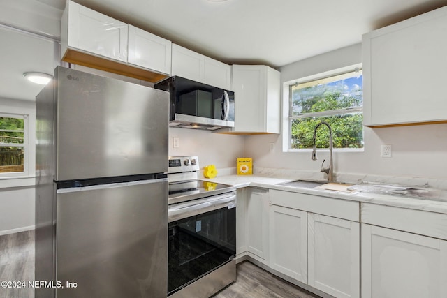 kitchen with a healthy amount of sunlight, white cabinetry, and stainless steel appliances