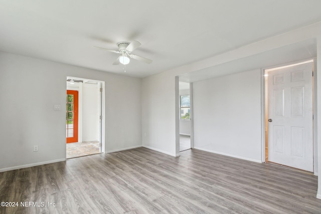 empty room featuring plenty of natural light, light hardwood / wood-style floors, and ceiling fan