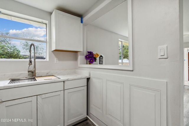 kitchen with hardwood / wood-style floors, a healthy amount of sunlight, white cabinetry, and sink