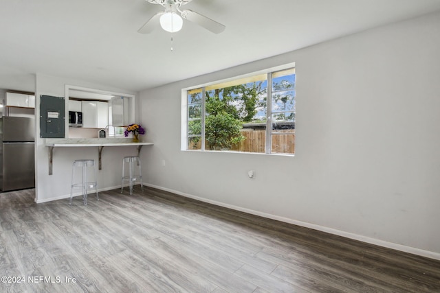 kitchen featuring ceiling fan, kitchen peninsula, hardwood / wood-style floors, a breakfast bar, and appliances with stainless steel finishes