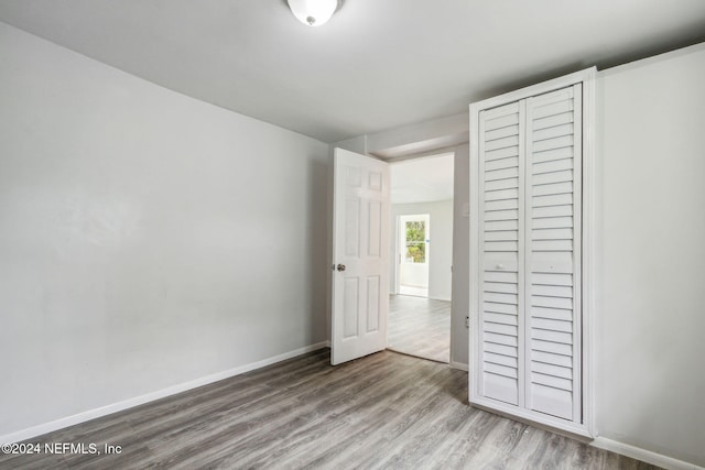 unfurnished bedroom featuring hardwood / wood-style floors and a closet