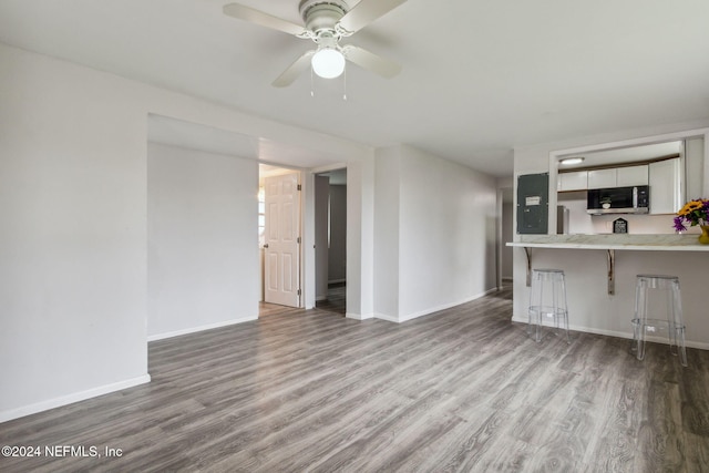 unfurnished living room with hardwood / wood-style flooring and ceiling fan