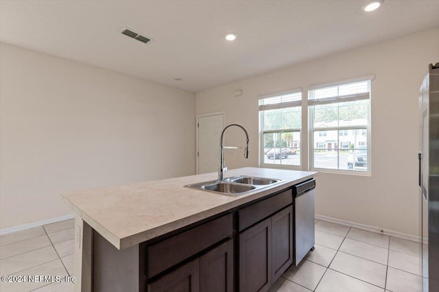 kitchen with appliances with stainless steel finishes, a center island with sink, light tile patterned floors, and sink