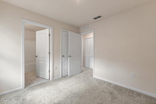 unfurnished bedroom featuring light carpet