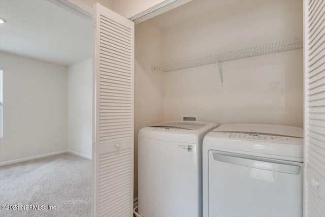 clothes washing area featuring washer and clothes dryer and carpet floors