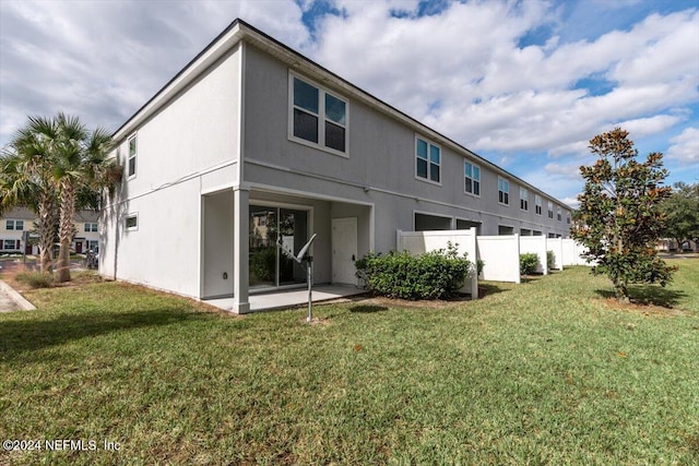 back of property with a patio area and a yard