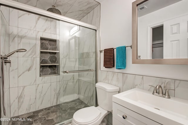 bathroom with vanity, an enclosed shower, tile walls, and toilet