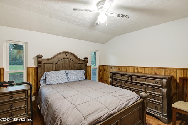 bedroom with hardwood / wood-style flooring, multiple windows, lofted ceiling, and ceiling fan