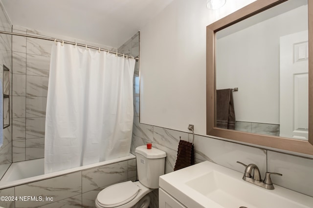 full bathroom featuring shower / bath combination with curtain, vanity, toilet, and tile walls