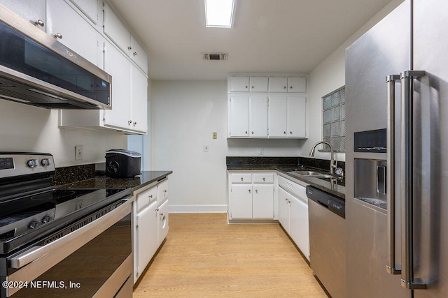 kitchen with sink, white cabinets, stainless steel appliances, and light hardwood / wood-style floors