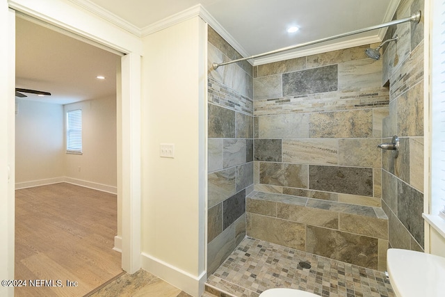 bathroom featuring a tile shower, ceiling fan, hardwood / wood-style floors, toilet, and ornamental molding