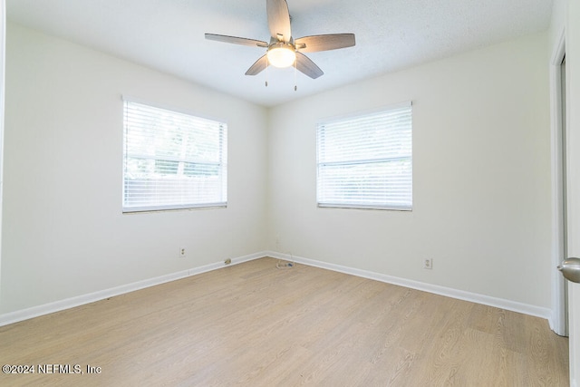 spare room featuring plenty of natural light, ceiling fan, and light hardwood / wood-style flooring