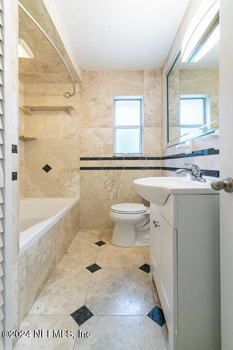 full bathroom with plenty of natural light, vanity, tile walls, and toilet