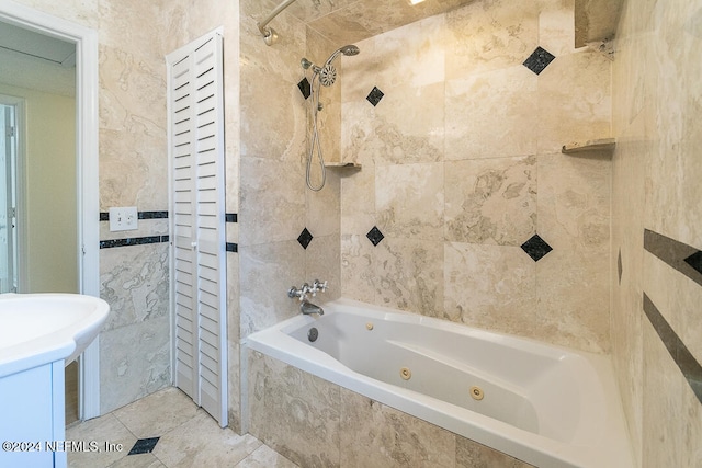 bathroom with tile patterned floors, tile walls, and tiled shower / bath