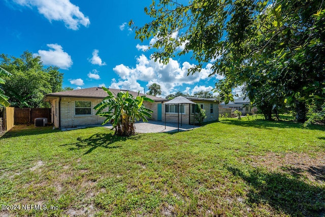 back of house featuring a lawn, central AC, and a patio